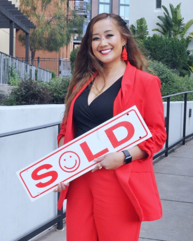 Jennifer Insisoulath, founder of The Millennial Agent, holding a SOLD sign outside a Bay Area home